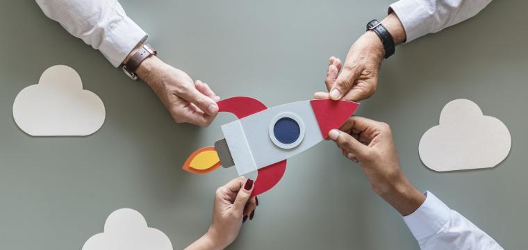 business people holding startup rocket
