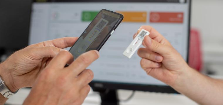 A smartphone being used to scan a lateral flow test.