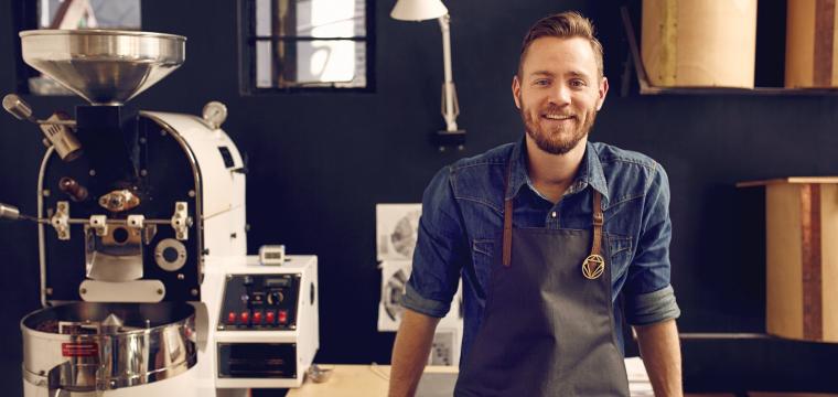 Owner of coffee shop smiling at camera 