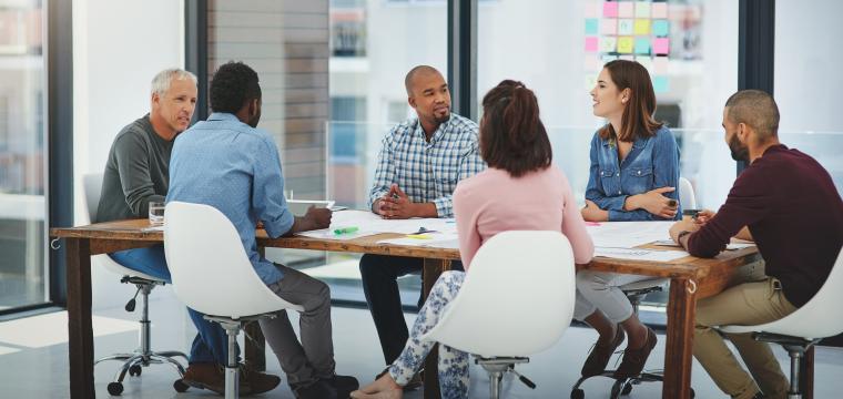 People sitting around a desk in a business meeting