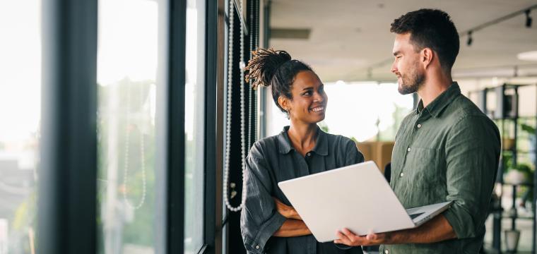 Two colleagues discussing work on a laptop