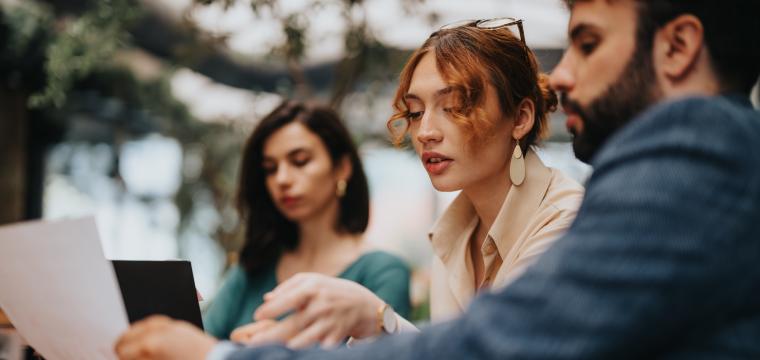 Colleagues discussing work on a sheet of paper