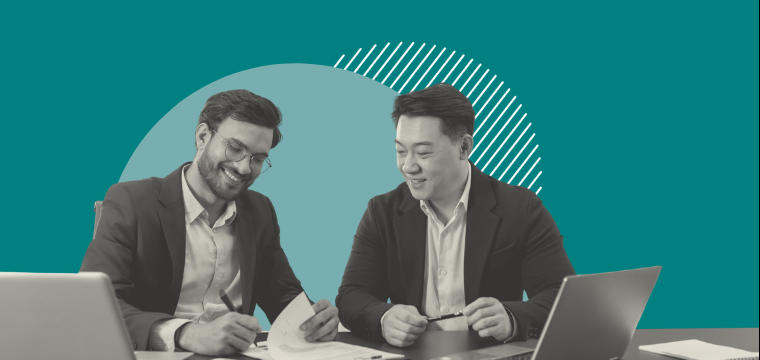 Two men sitting by a laptop