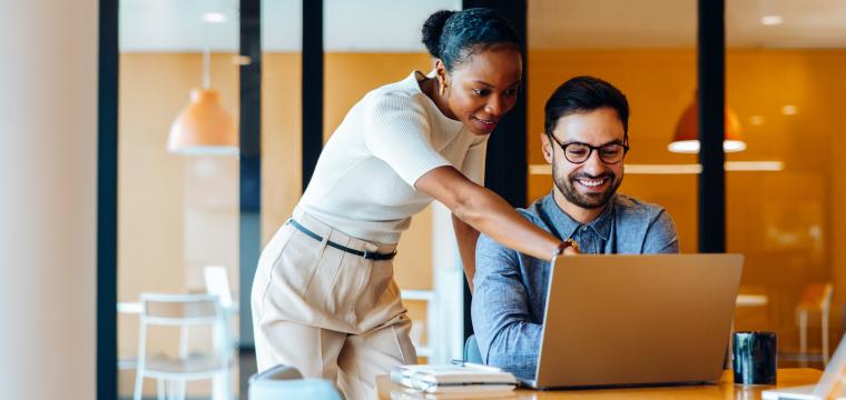 Two colleagues discussing work on a laptop