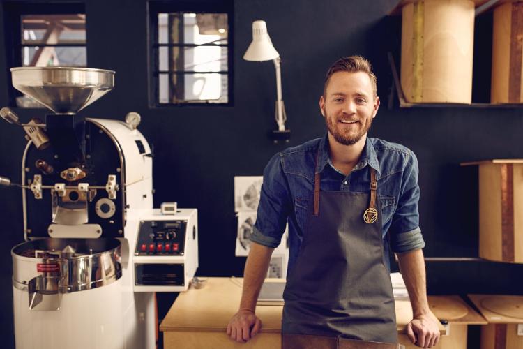 Owner of coffee shop smiling at camera 