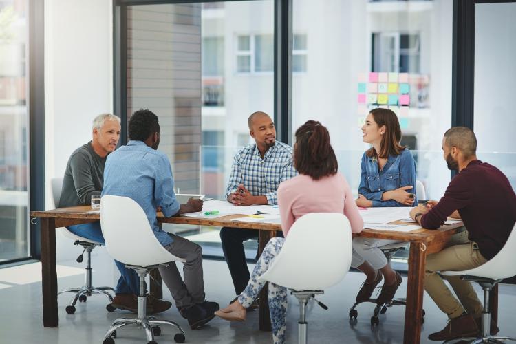 People sitting around a desk in a business meeting
