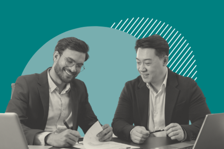 Two men sitting by a laptop