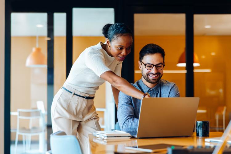 Two colleagues discussing work on a laptop